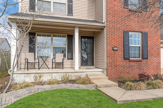 view of exterior entry featuring covered porch