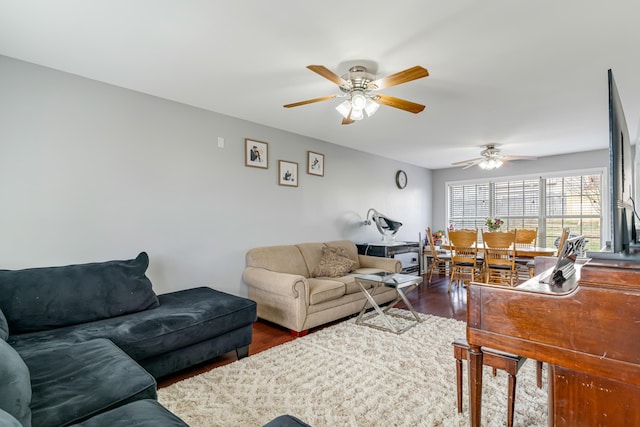 living room with a ceiling fan and dark wood-type flooring