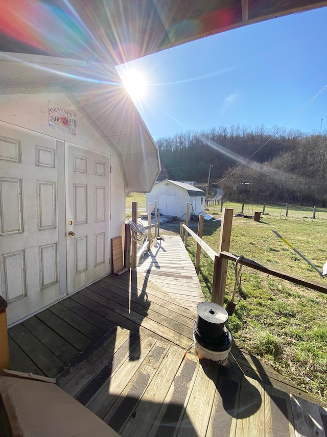 deck with an outbuilding, a yard, and a storage unit