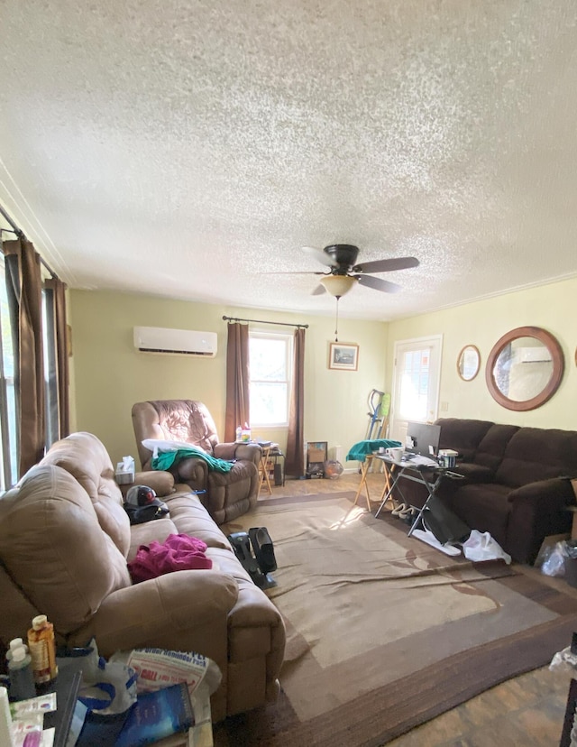 living room featuring a textured ceiling, a ceiling fan, and a wall mounted AC