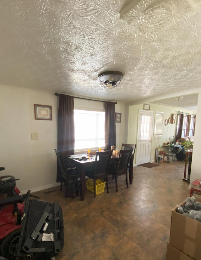 dining room with baseboards and a textured ceiling