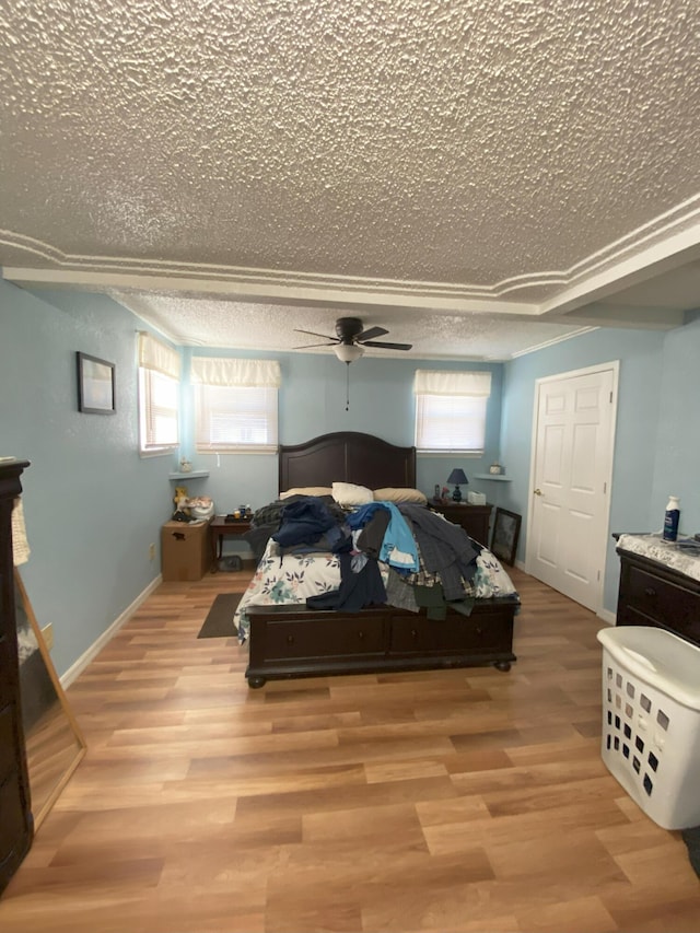 bedroom featuring a ceiling fan, light wood-type flooring, multiple windows, and baseboards