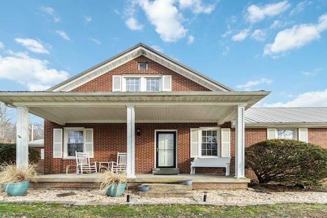 view of front of house with a porch and brick siding