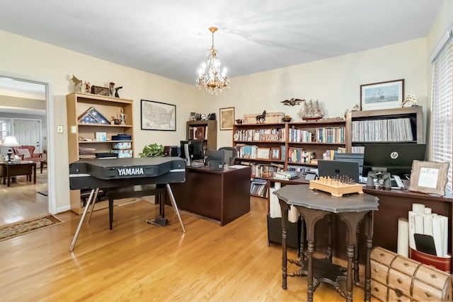 office space with light wood-style flooring and an inviting chandelier