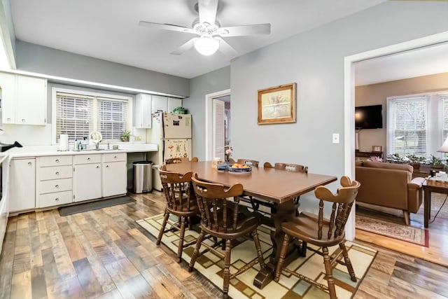 dining area with light wood finished floors and ceiling fan