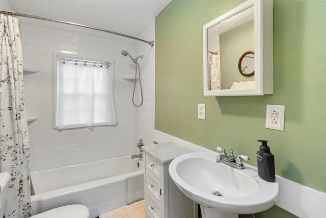 full bath featuring a sink, toilet, and shower / bath combo with shower curtain