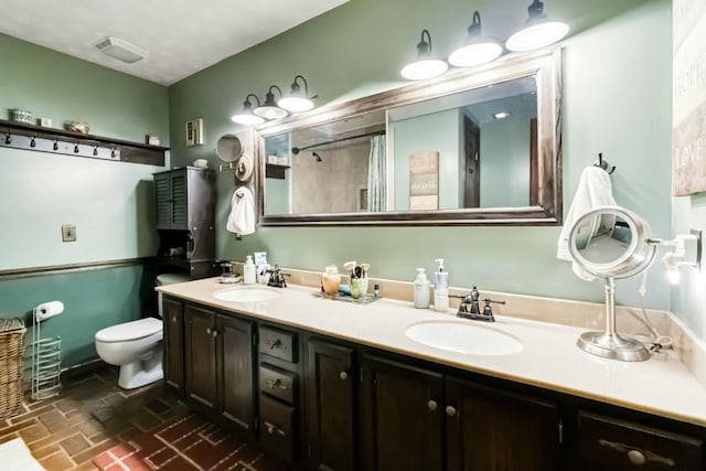 full bathroom with a shower with shower curtain, a sink, toilet, and double vanity