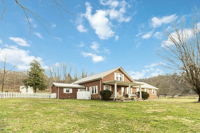 view of front of home with brick siding, a front lawn, a porch, and fence