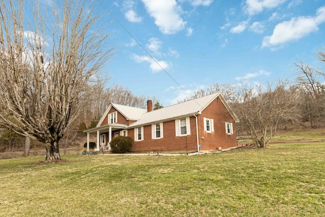 view of property exterior featuring brick siding, a yard, and a chimney