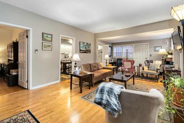 living area featuring light wood-style floors and baseboards