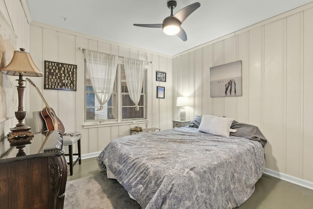 bedroom featuring ornamental molding, a ceiling fan, and a decorative wall