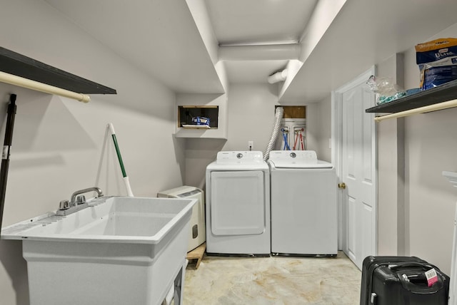 clothes washing area with laundry area, a sink, and washing machine and clothes dryer