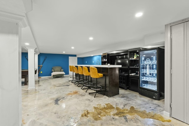 bar with a dry bar, baseboards, unfinished concrete flooring, and recessed lighting