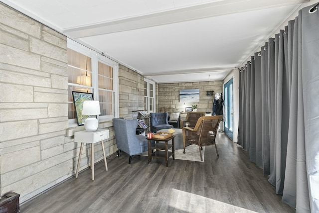 living area featuring beamed ceiling, wood finished floors, and a sunroom