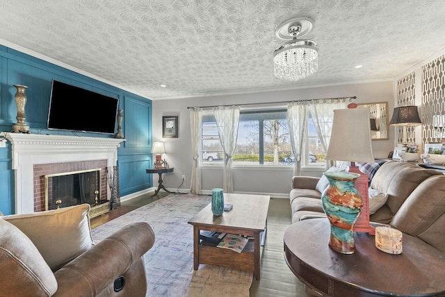 living room with a brick fireplace, crown molding, a textured ceiling, and baseboards