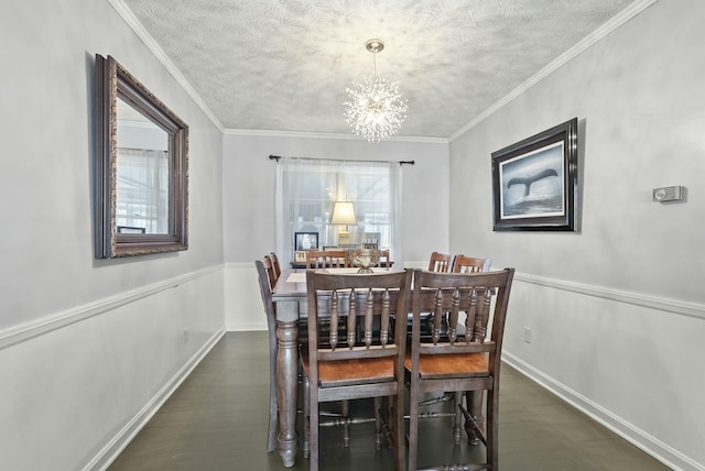 dining area with a textured ceiling, ornamental molding, dark wood-style flooring, and an inviting chandelier