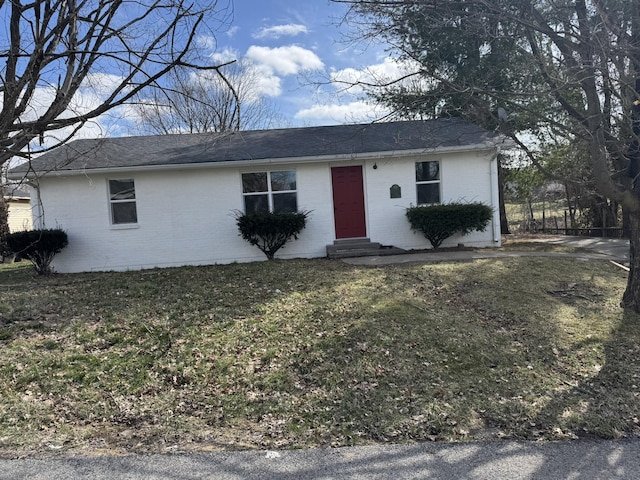 ranch-style home featuring entry steps, brick siding, and a front yard