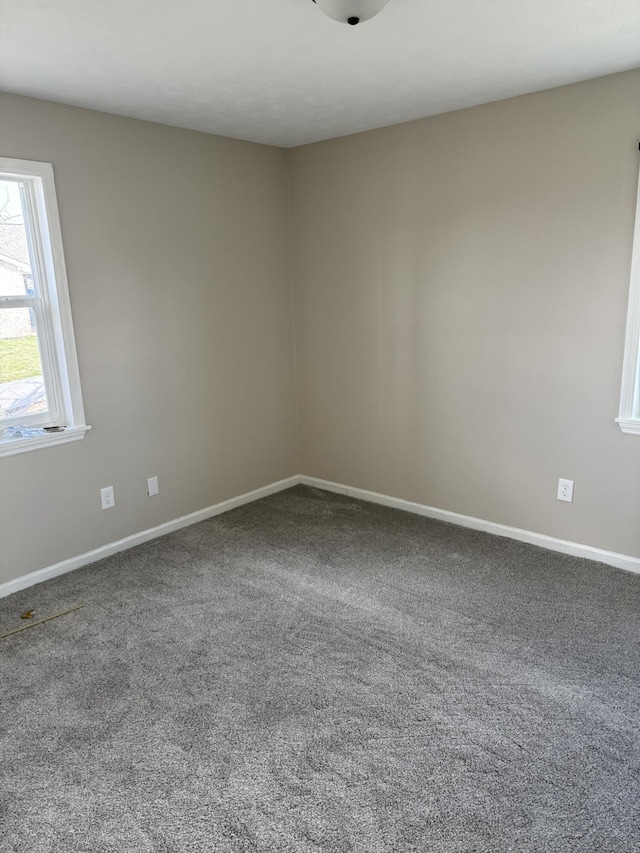 carpeted empty room featuring baseboards