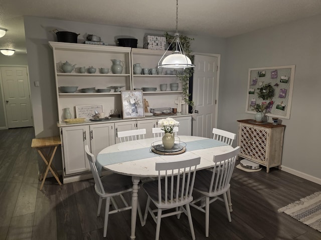 dining space featuring dark wood-style floors and baseboards