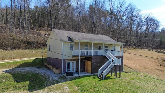 view of front of home with stairs, roof with shingles, french doors, and a front lawn