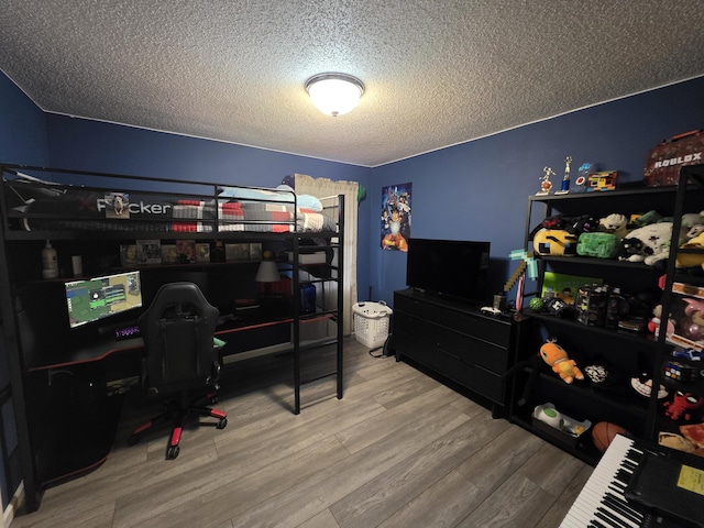 bedroom featuring a textured ceiling and wood finished floors