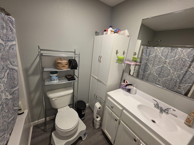 full bathroom featuring baseboards, vanity, toilet, and wood finished floors