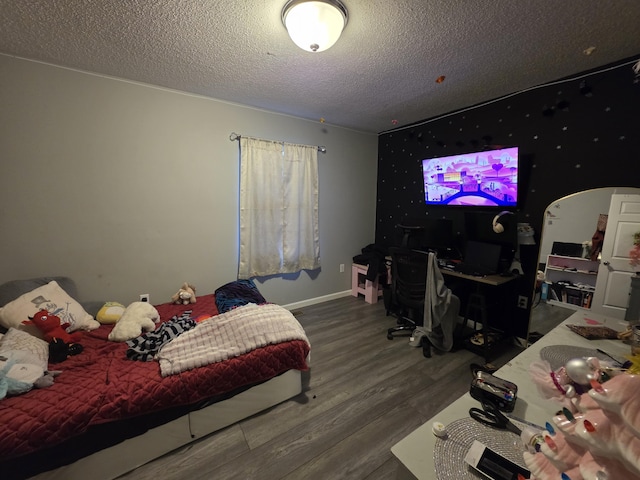 bedroom with a textured ceiling and wood finished floors