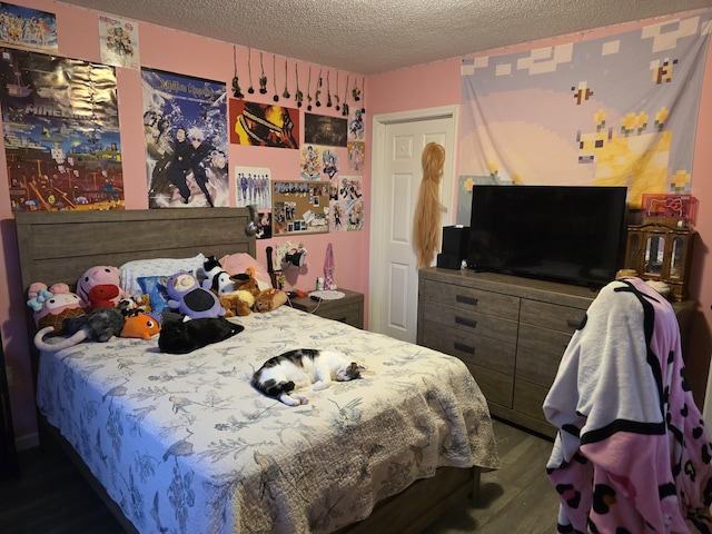 bedroom with a textured ceiling and wood finished floors