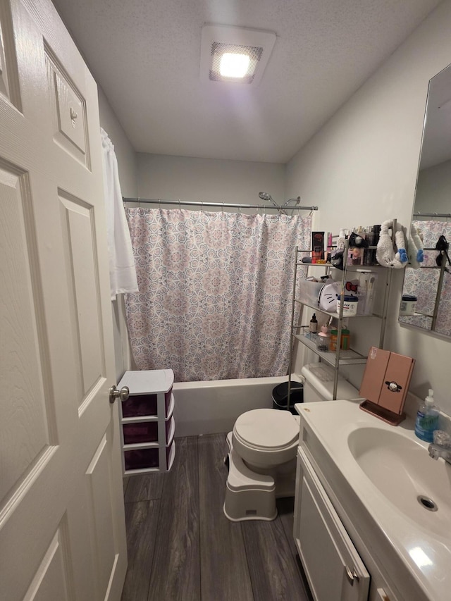 bathroom with toilet, shower / tub combo, a textured ceiling, and wood finished floors