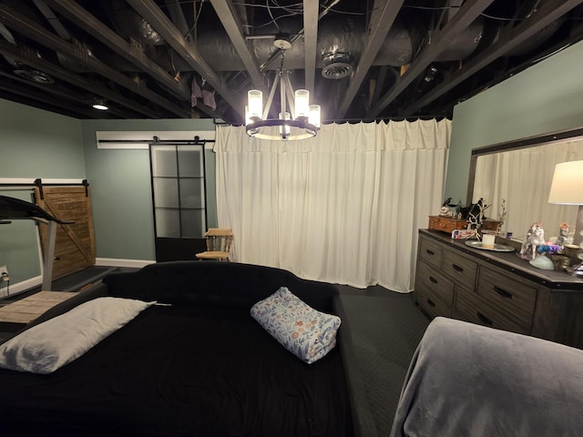 bedroom featuring a notable chandelier, baseboards, and a barn door