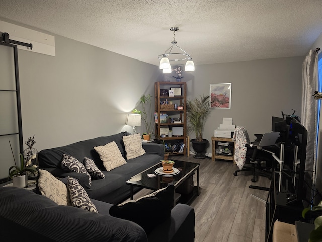 living room with hardwood / wood-style flooring, a barn door, and a textured ceiling