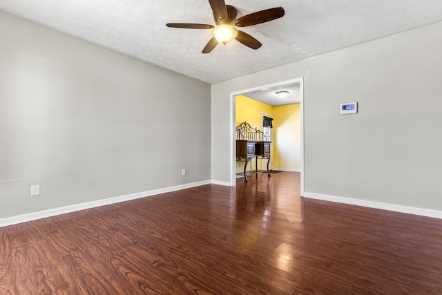 empty room featuring baseboards, a textured ceiling, wood finished floors, and a ceiling fan