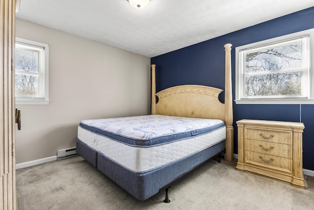 bedroom featuring light colored carpet, baseboards, baseboard heating, and a textured ceiling