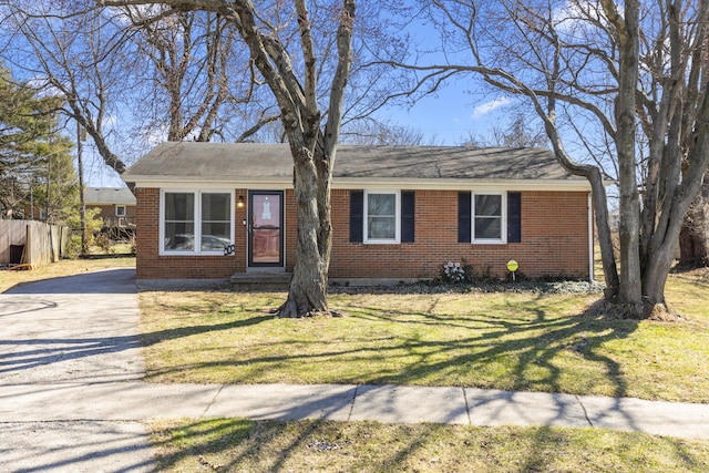 view of front of property featuring brick siding, driveway, and a front lawn