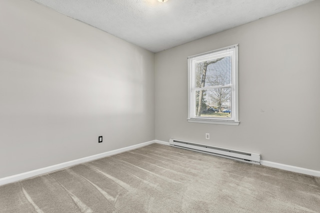 carpeted spare room featuring a textured ceiling, baseboards, and a baseboard radiator