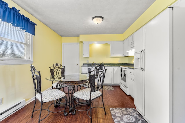 dining area with a baseboard heating unit, dark wood finished floors, and baseboards