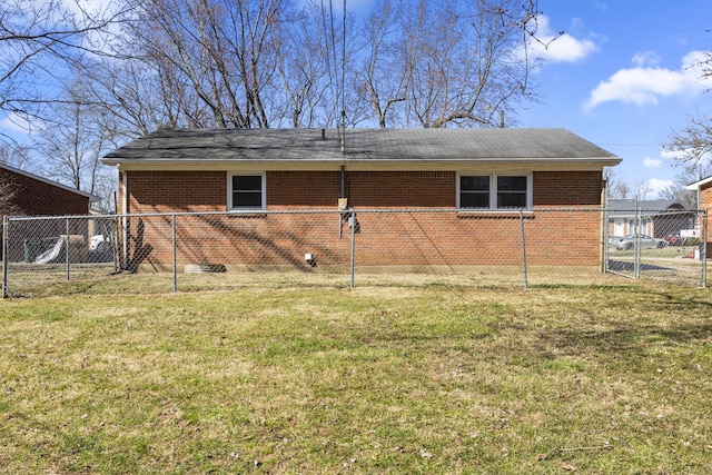 back of property featuring a gate, a yard, fence, and brick siding