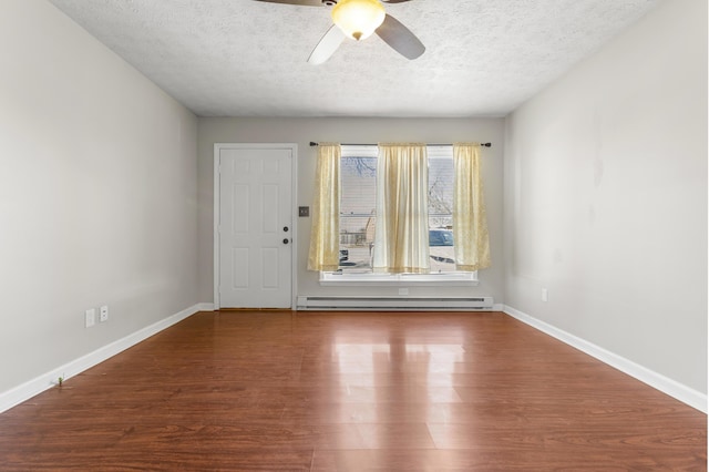 interior space with a baseboard heating unit, baseboards, a textured ceiling, and wood finished floors