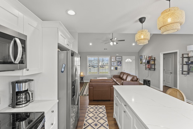 kitchen with open floor plan, appliances with stainless steel finishes, dark wood-style floors, and white cabinetry