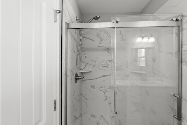 full bathroom featuring a marble finish shower