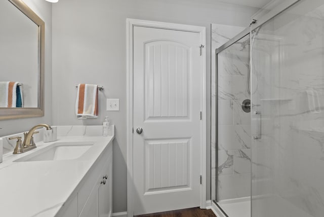 bathroom with a marble finish shower and vanity