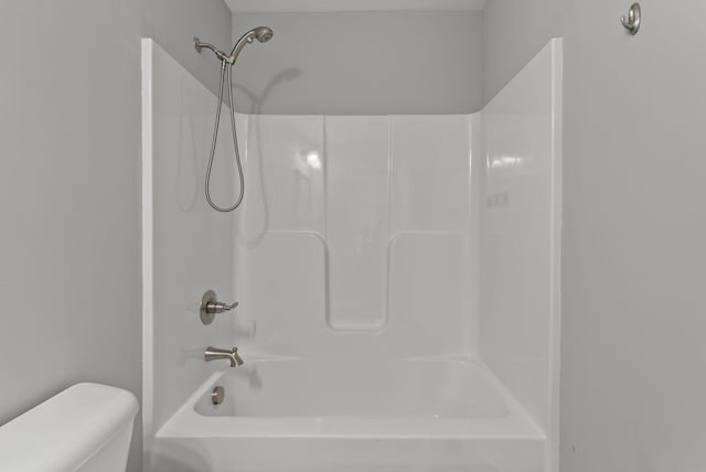 bathroom with shower / bathing tub combination and toilet