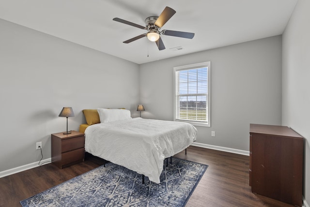 bedroom with a ceiling fan, visible vents, baseboards, and wood finished floors