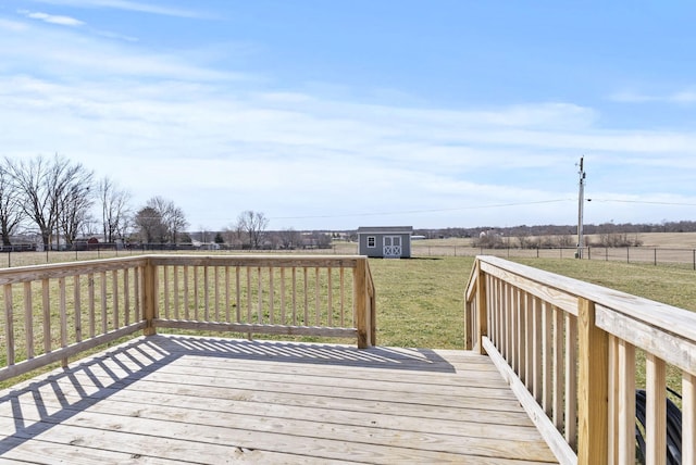 wooden deck with an outbuilding, a yard, a rural view, and a fenced backyard