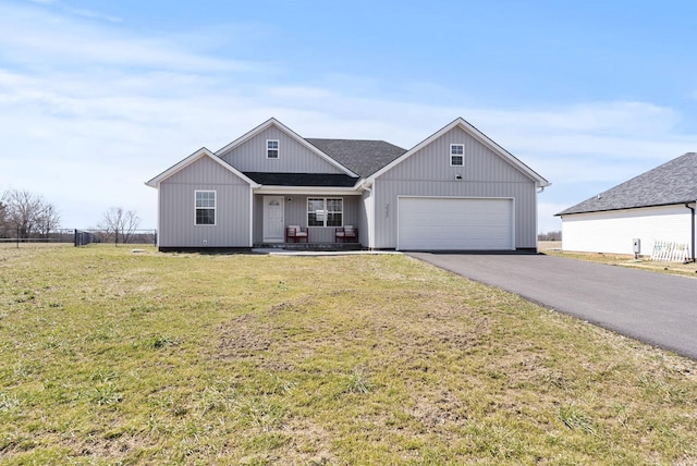 view of front of house with a porch, an attached garage, fence, driveway, and a front yard