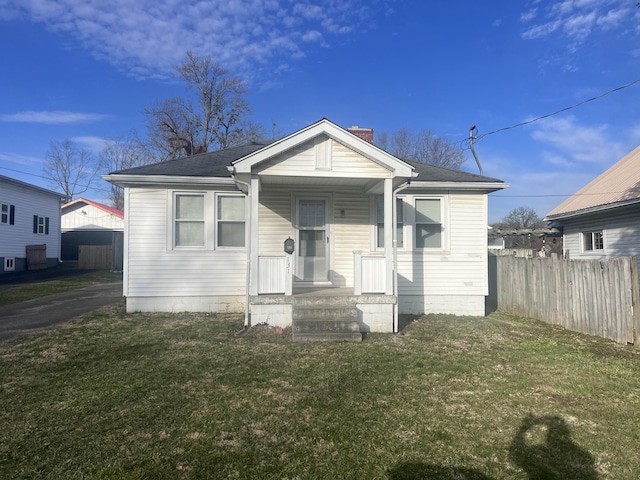 bungalow-style home featuring driveway, a front lawn, a porch, and fence