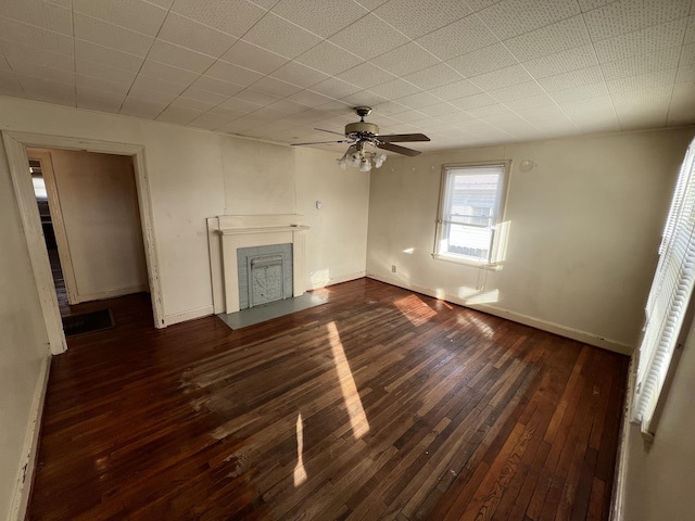 unfurnished living room featuring a fireplace with flush hearth, baseboards, ceiling fan, and dark wood-type flooring