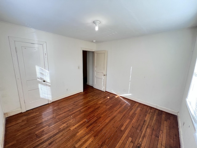 spare room featuring hardwood / wood-style flooring and baseboards