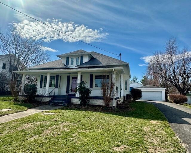 bungalow featuring a porch, a front yard, an outdoor structure, and a detached garage