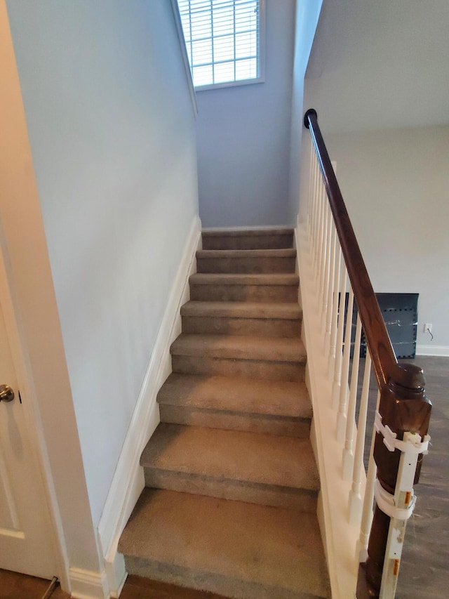 staircase with baseboards and wood finished floors